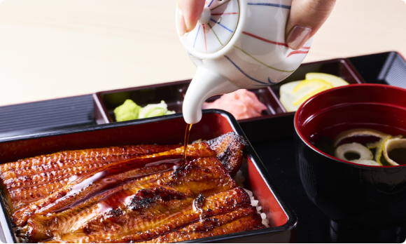 うな重にタレをかけている瞬間