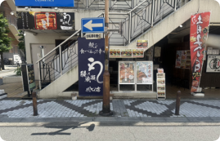 正面に階段のあるマンションの1階階段奥が当店の入口となります。